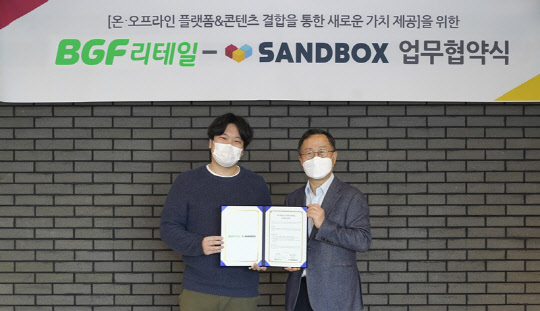 BGF리테일이 샌드박스와 MOU를 체결했다. 사진은 이건준(우측) BGF리테일 대표와 이필성(좌측) 샌드박스네트워크 대표 <BGF리테일 제공>